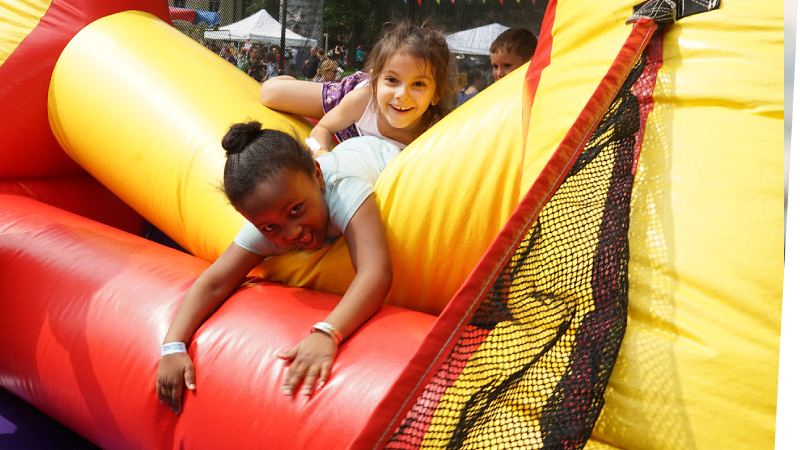 childrens laughing as they tumble out of a bounce house
