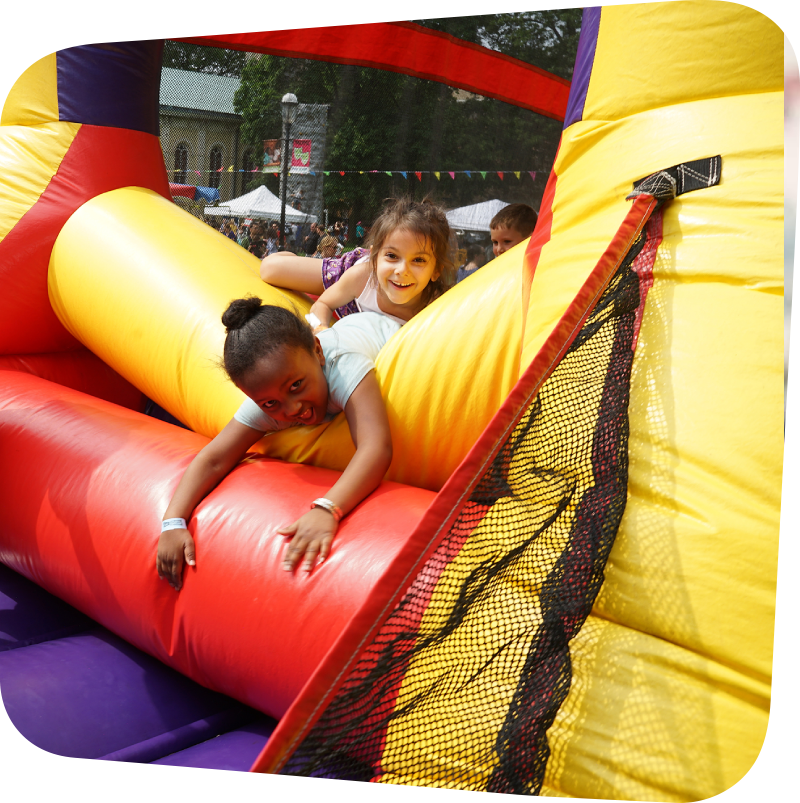 childrens laughing as they tumble out of a bounce house