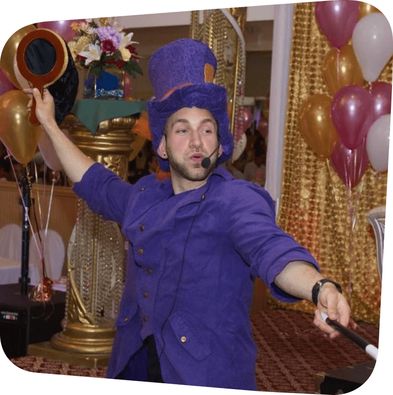 Magician in purple jacket and top hat waving a wand