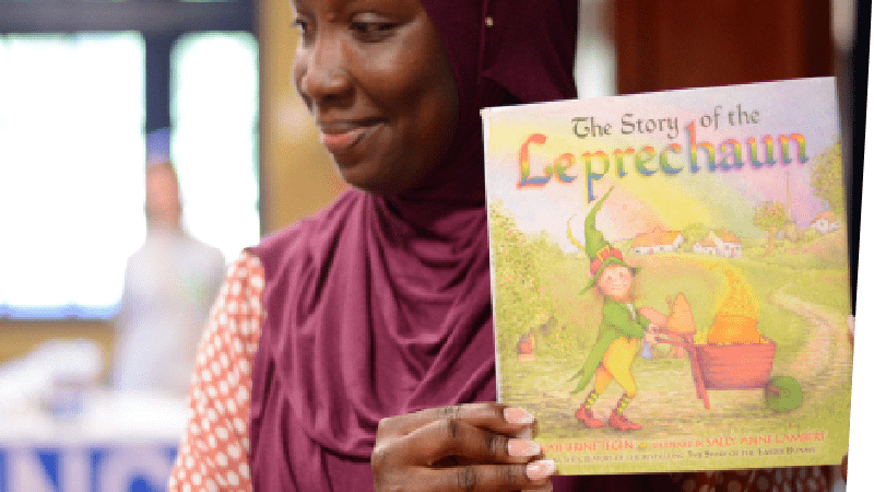 Woman displaying the cover of a children's book