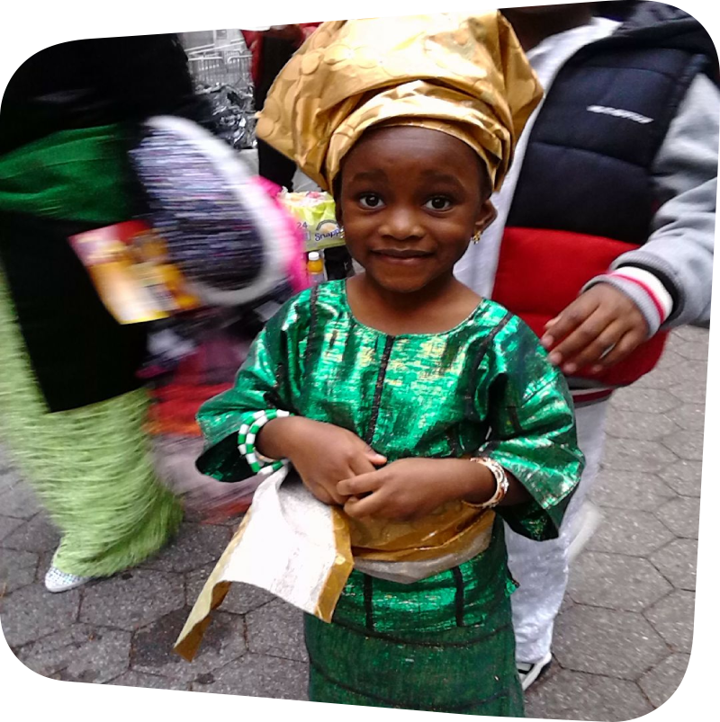 Girl wearing traditional green and gold Nigerian clothes at Nigerian Independence Day parade
