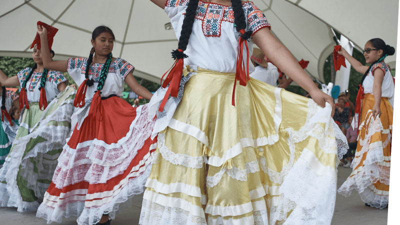 Female performers cultural attire preforming a dance