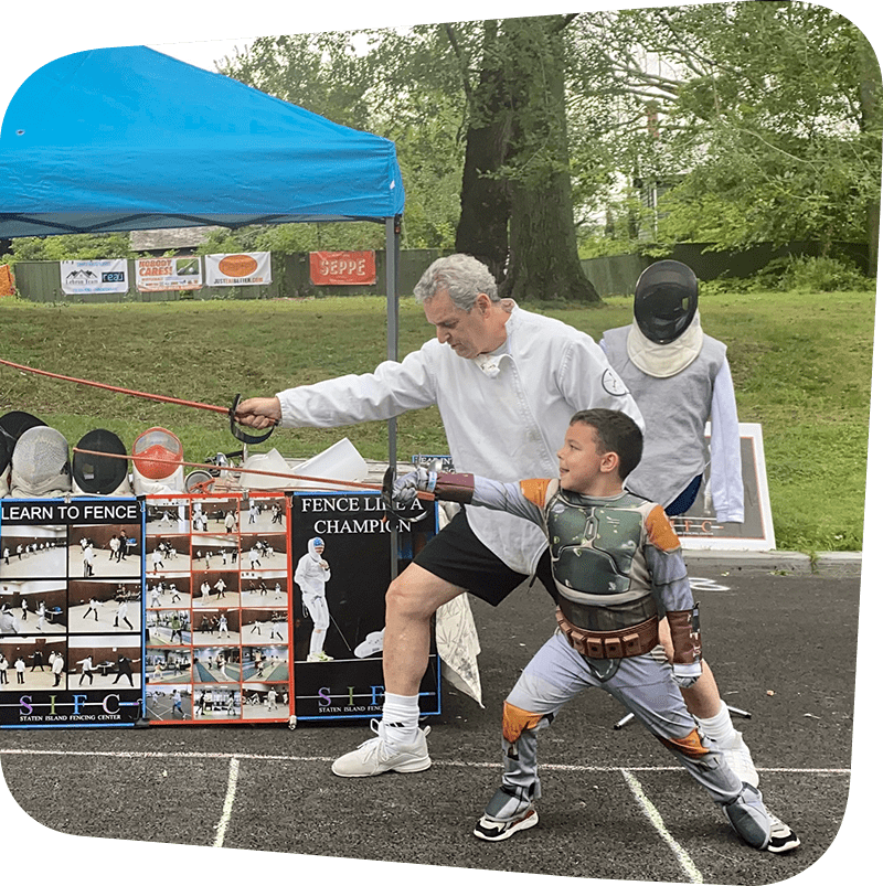 man demonstrating fencing to a young boy