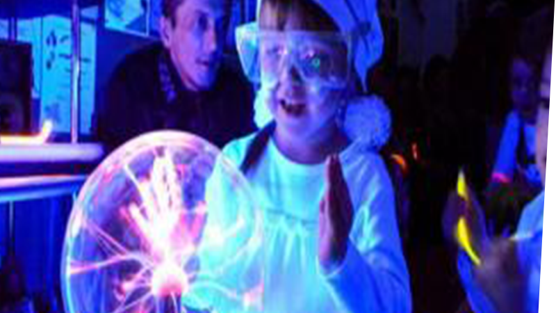 child with safety goggles touching a glowing ball of electricity